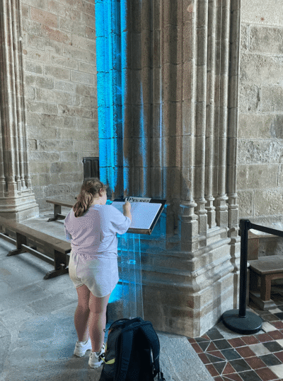 Emilie qui écrit une prière dans l'Abbaye du Mont-Saint-Michel